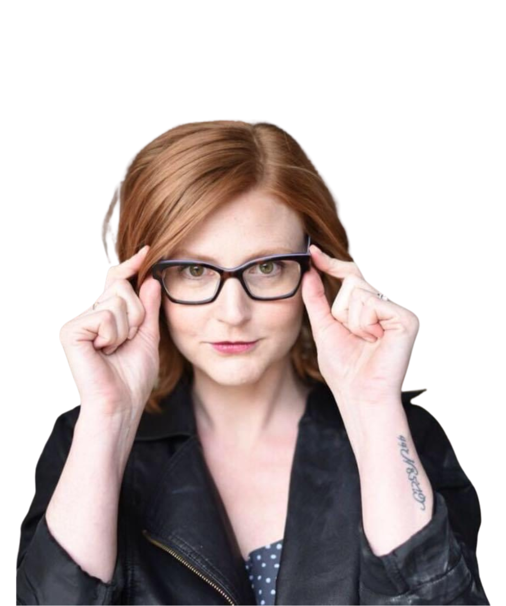 a red haired woman wearing a black leather jacket holding the frames of her glasses.